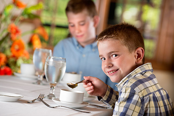 Children at dining table for etiquette class