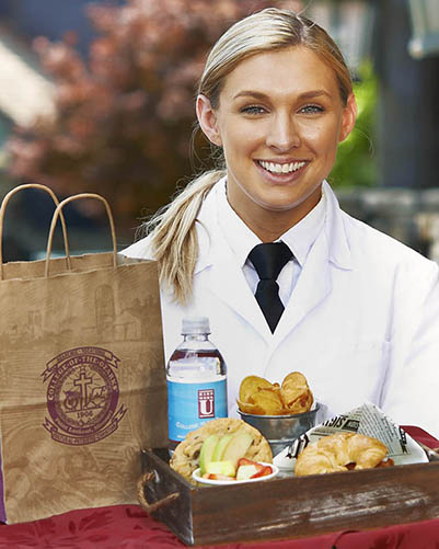 Student server carrying a to-go tray of food